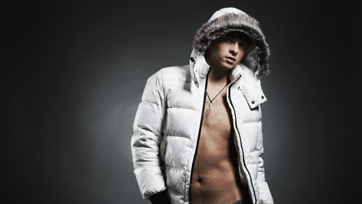Male creator in a white puffer jacket against a dark background